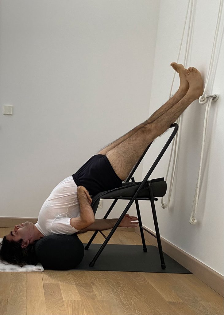Gyaan Lyon in supported Chair Sarvangasana